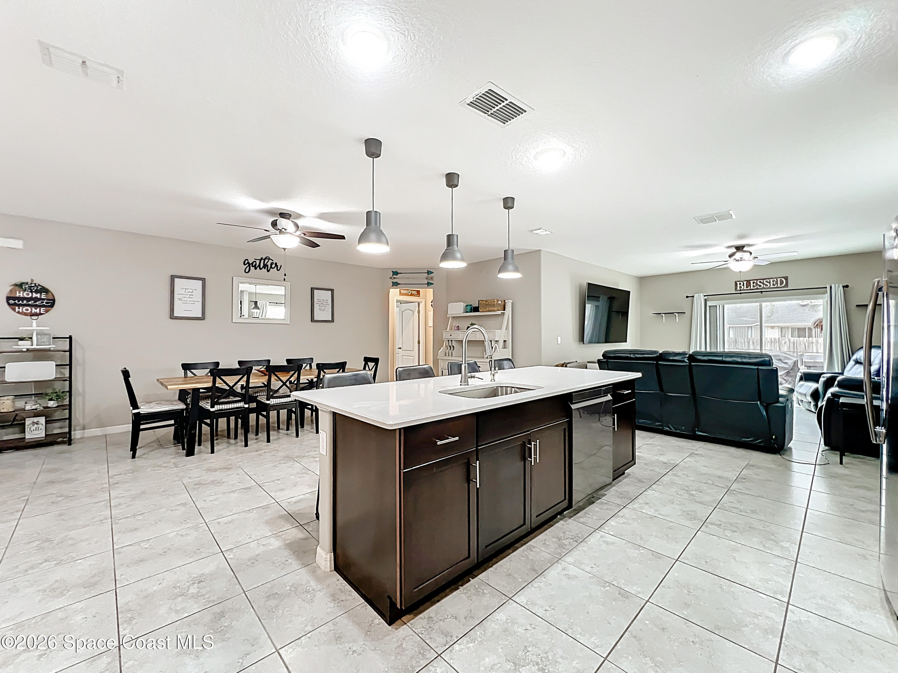 415 Scodella Street Southwest Palm Bay, FL 32908 - Photo 19 of 54 a large kitchen with kitchen island a sink table and chairs