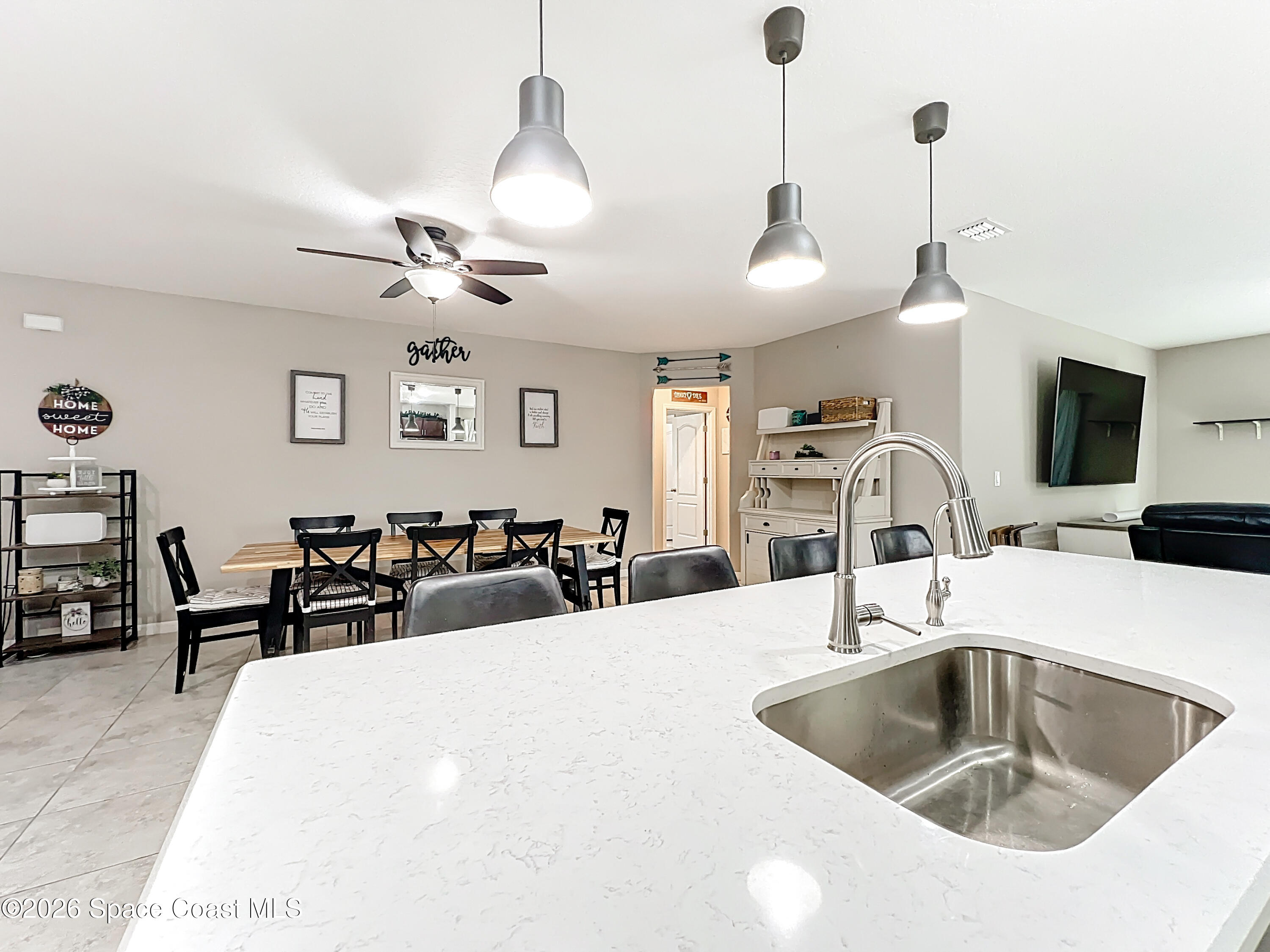415 Scodella Street Southwest Palm Bay, FL 32908 - Photo 20 of 54 a kitchen with stainless steel appliances a sink a flat screen tv and couches