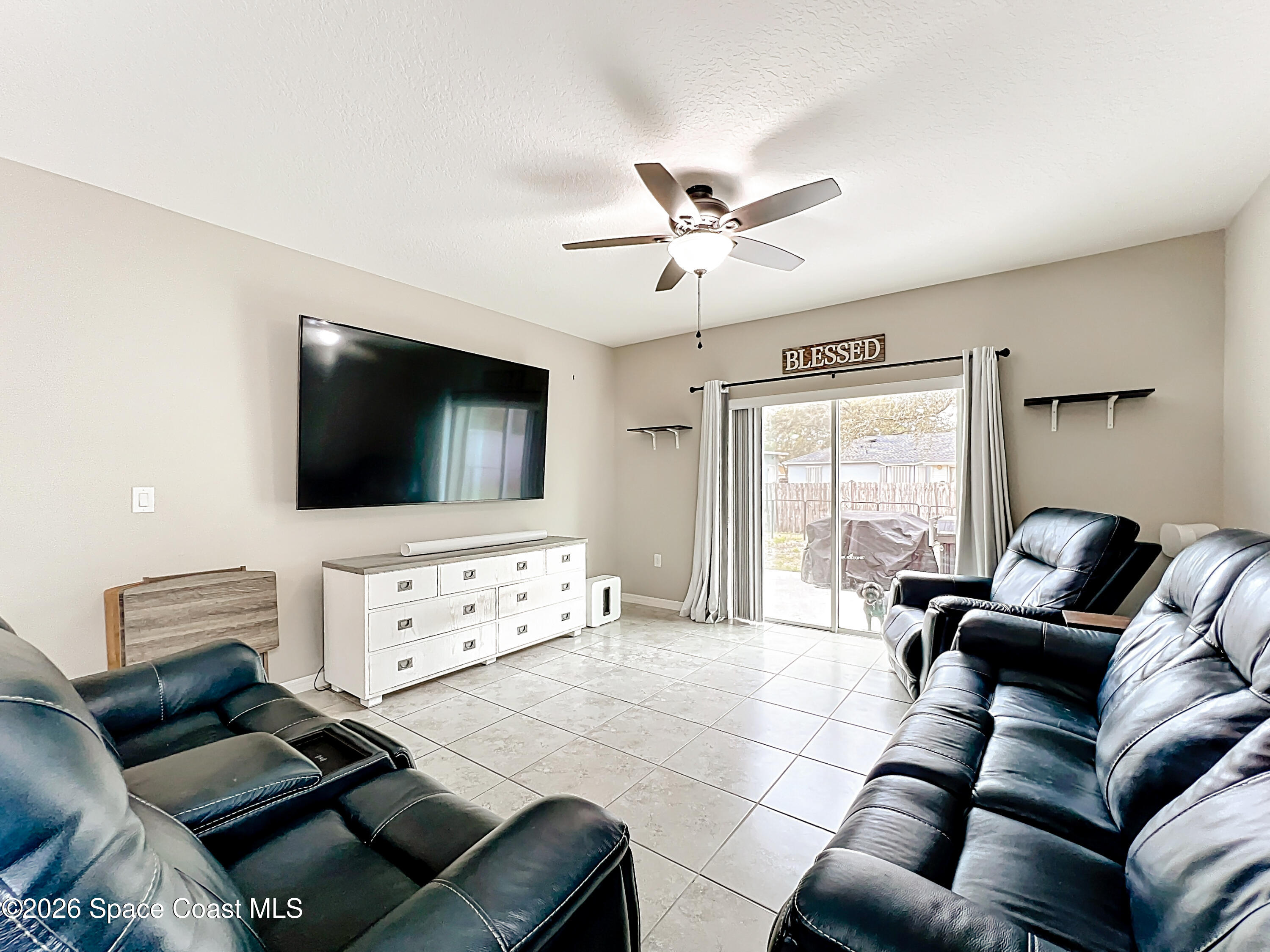 415 Scodella Street Southwest Palm Bay, FL 32908 - Photo 26 of 54 a living room with furniture and a flat screen tv