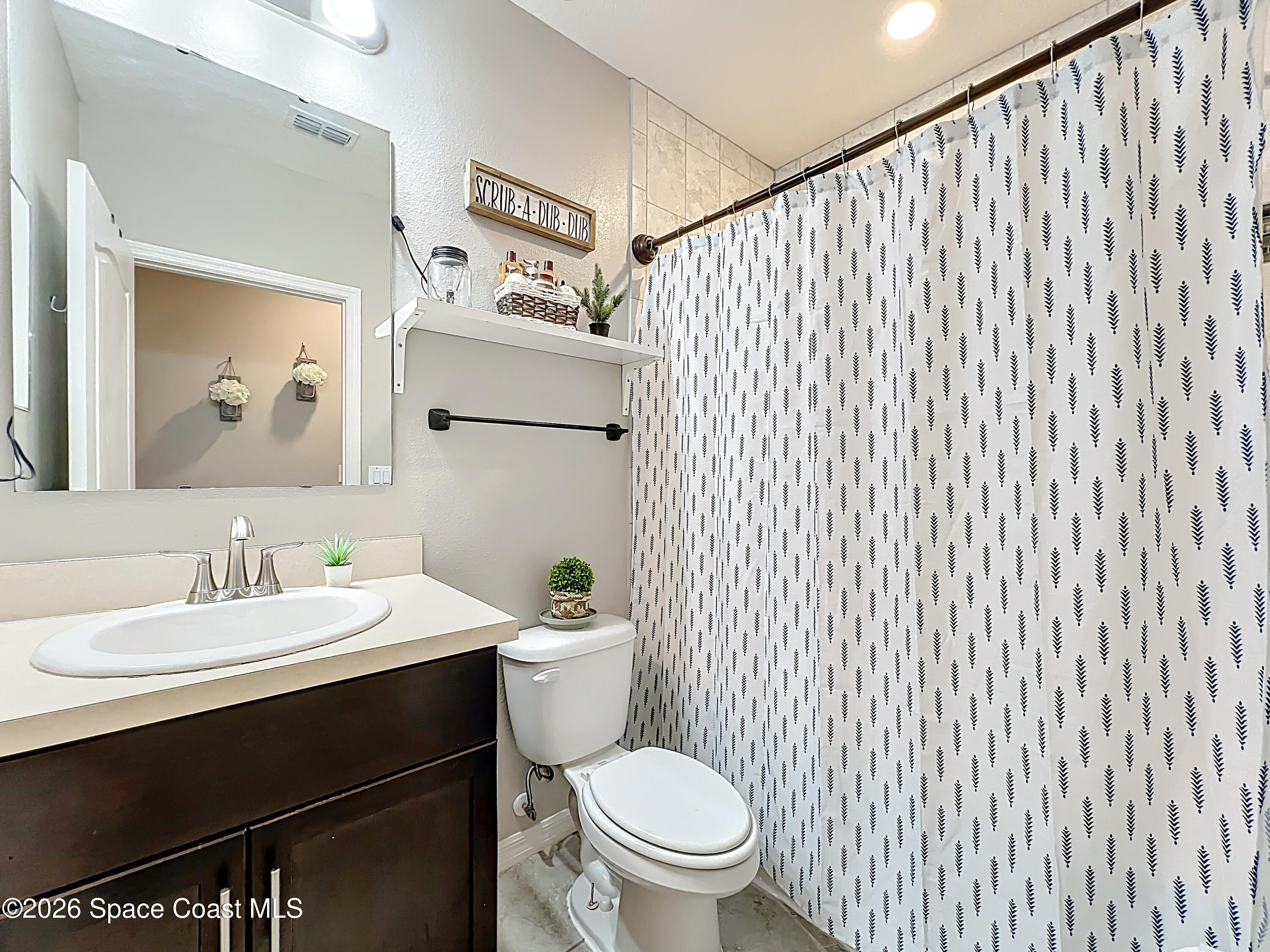 415 Scodella Street Southwest Palm Bay, FL 32908 - Photo 42 of 54 a white toilet sitting next to a bathroom sink