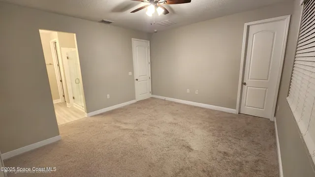 an empty room with a fan and a window