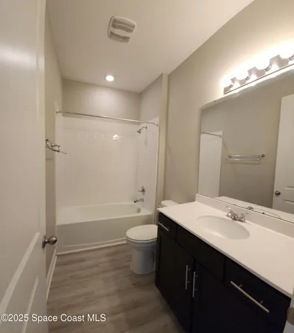 a bathroom with a sink a toilet a mirror and shower