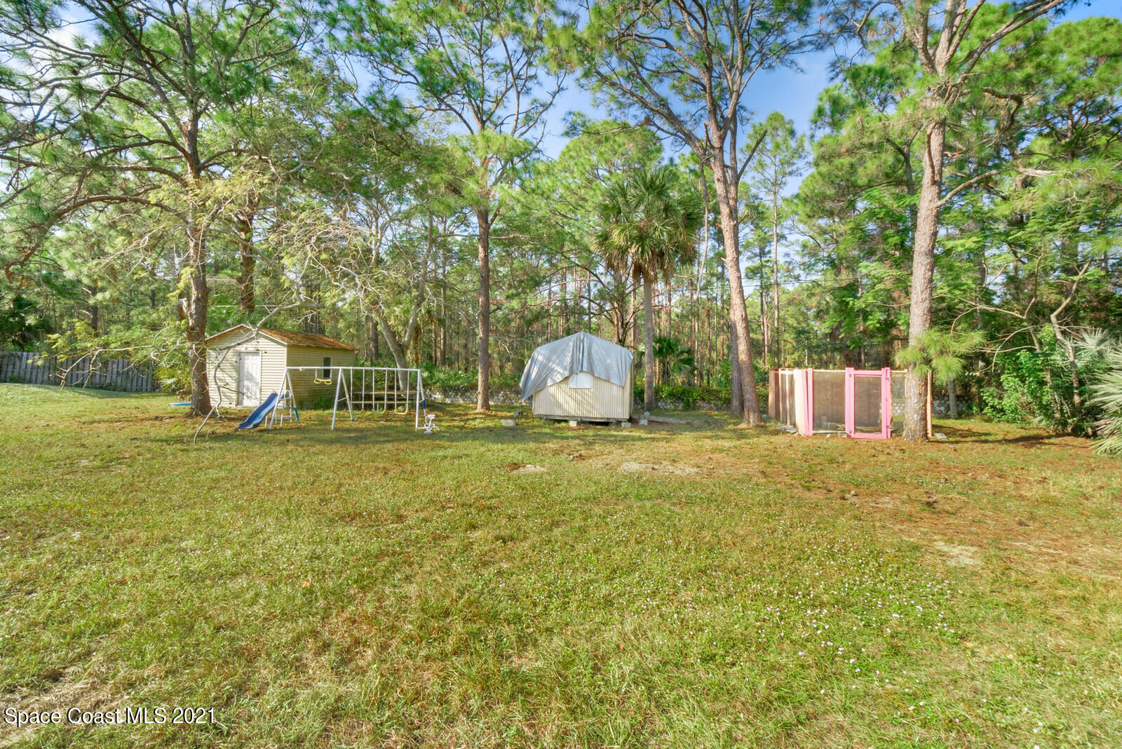 1424 Hanscom Road Southwest Palm Bay, FL 32908 - Photo 15 of 16 a backyard of a house with table and chairs