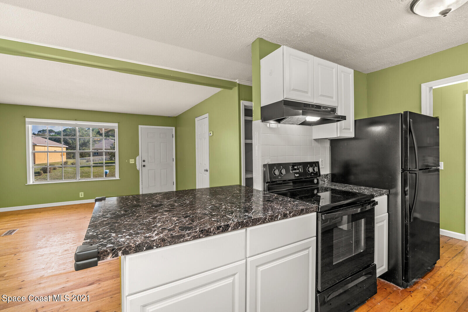1424 Hanscom Road Southwest Palm Bay, FL 32908 - Photo 5 of 16 a kitchen with stainless steel appliances granite countertop a refrigerator a stove and a sink with cabinets
