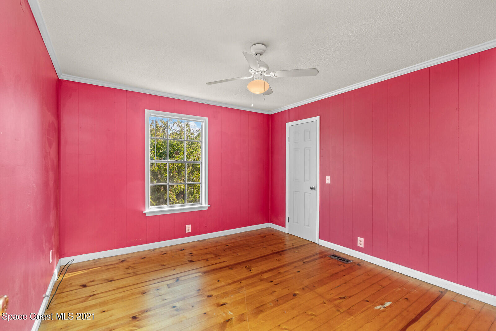 1424 Hanscom Road Southwest Palm Bay, FL 32908 - Photo 9 of 16 a view of an empty room with window ceiling fan and wooden floor