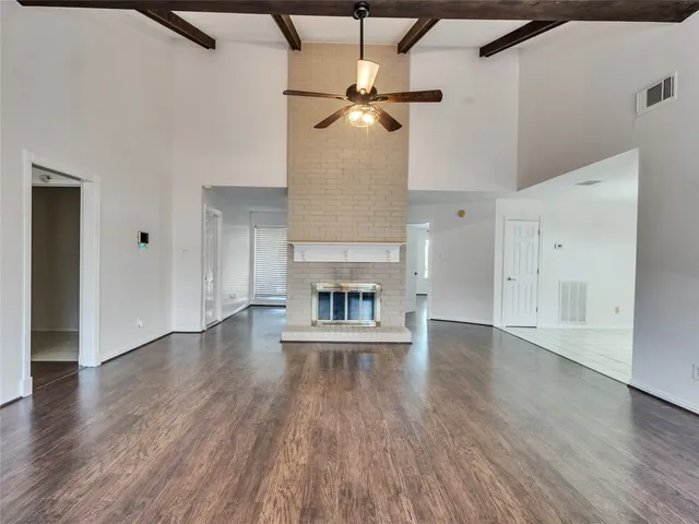 a view of an empty room with a fireplace and a window