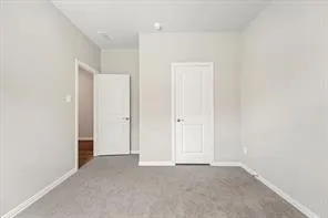 an empty room with a chandelier fan and windows