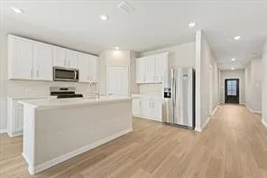 a kitchen with white cabinets sink and stainless steel appliances