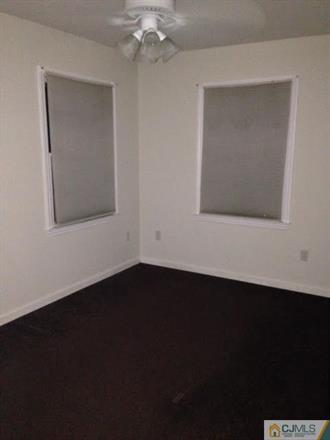164 Eastern Way Rutherford, NJ 07070 - Photo 18 of 25 a view of an empty room with wooden floor and a window