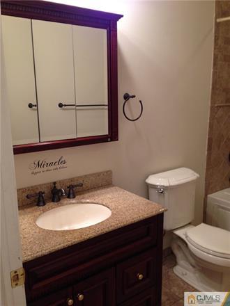 164 Eastern Way Rutherford, NJ 07070 - Photo 23 of 25 a bathroom with a granite countertop sink and a toilet