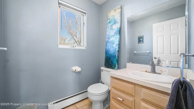 a bathroom with a granite countertop toilet a sink and a mirror