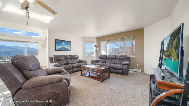 a living room with furniture a flat screen tv and a window