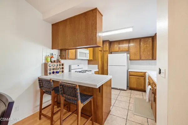 a kitchen with a table chairs refrigerator and microwave