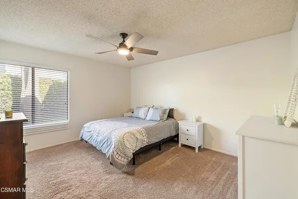 a bed room with a bed and a ceiling fan