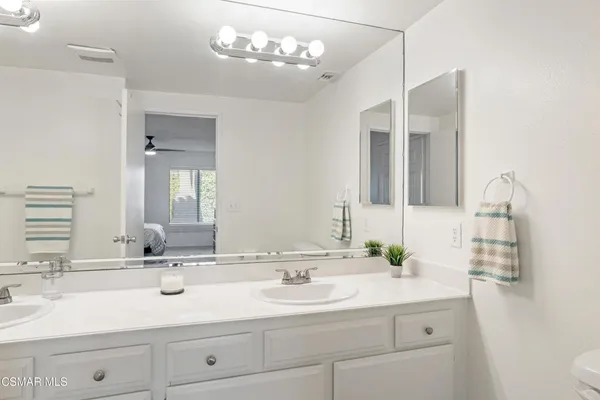 a bathroom with a sink a toilet and a mirror