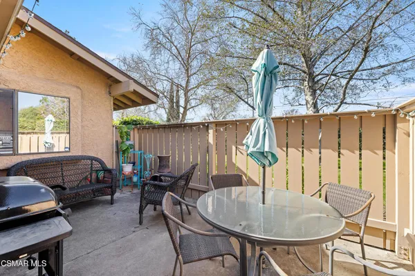 a backyard of a house with barbeque oven table and chairs