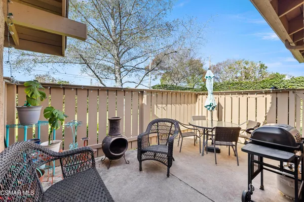 a view of a patio with a table chairs and a potted plant