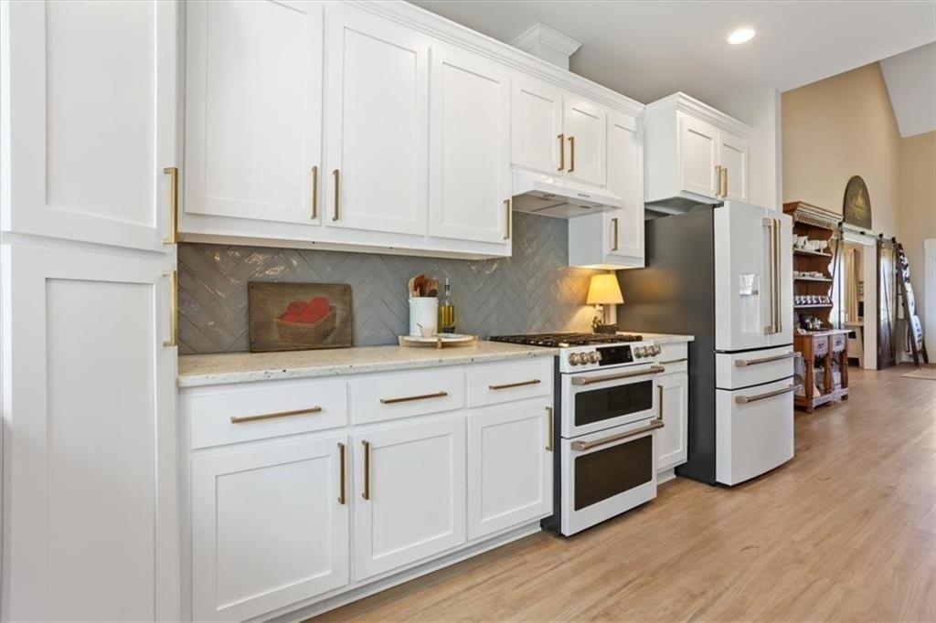 14402 Fincher Road Ball Ground, GA 30107 - Photo 21 of 55 a kitchen with stainless steel appliances white cabinets and wooden floors