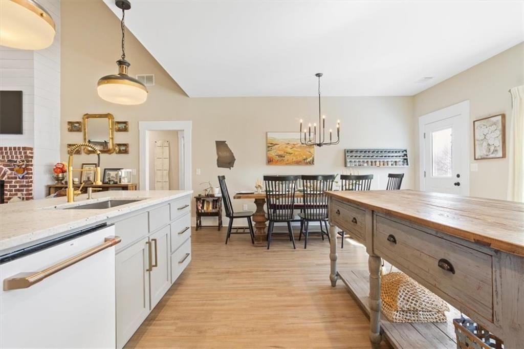 14402 Fincher Road Ball Ground, GA 30107 - Photo 24 of 55 a large kitchen with kitchen island a sink table and chairs