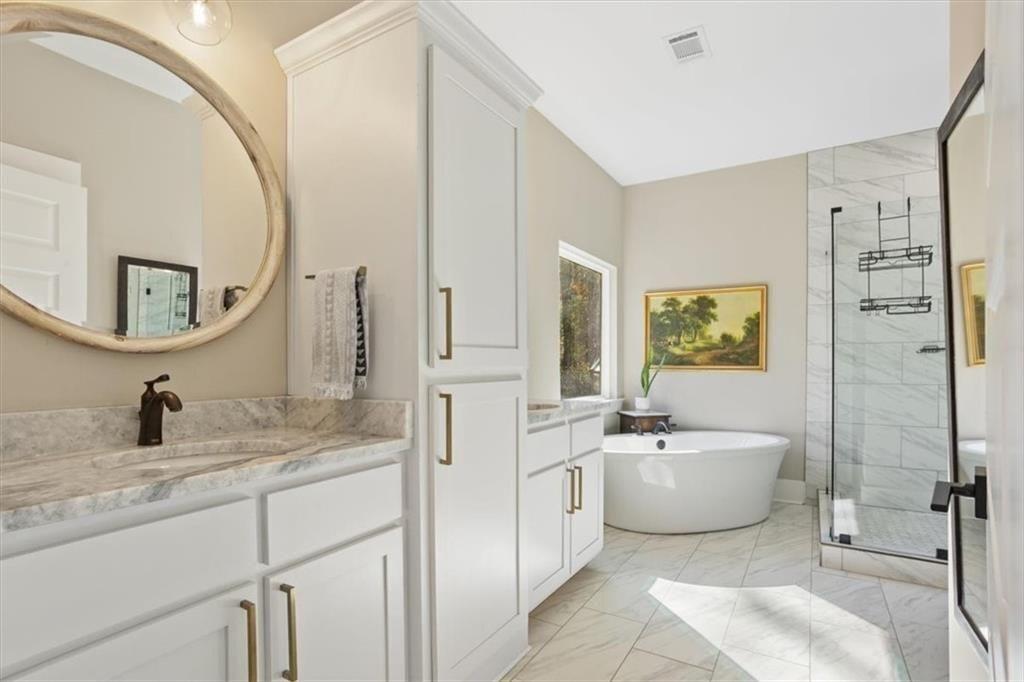 14402 Fincher Road Ball Ground, GA 30107 - Photo 30 of 55 a bathroom with a double vanity sink a mirror and a bathtub
