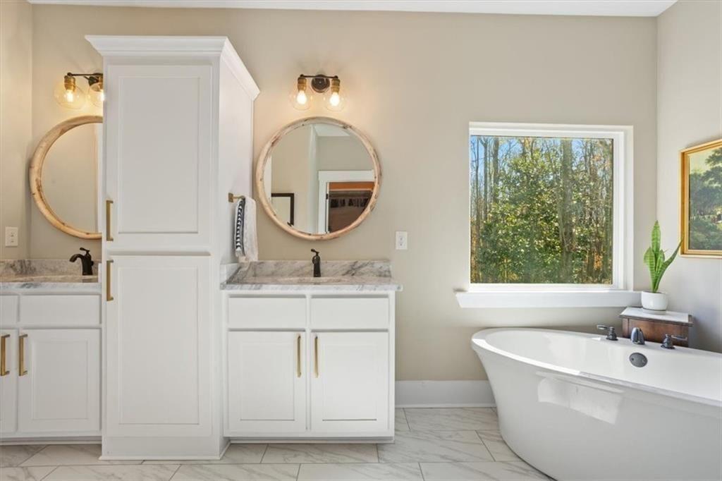 14402 Fincher Road Ball Ground, GA 30107 - Photo 32 of 55 a bathroom with a sink a mirror and a window