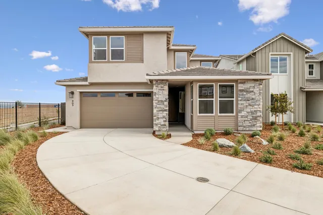 a front view of a house with a garage and glass door
