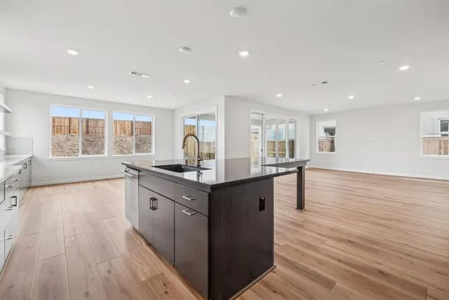 a kitchen with counter top space and wooden floor