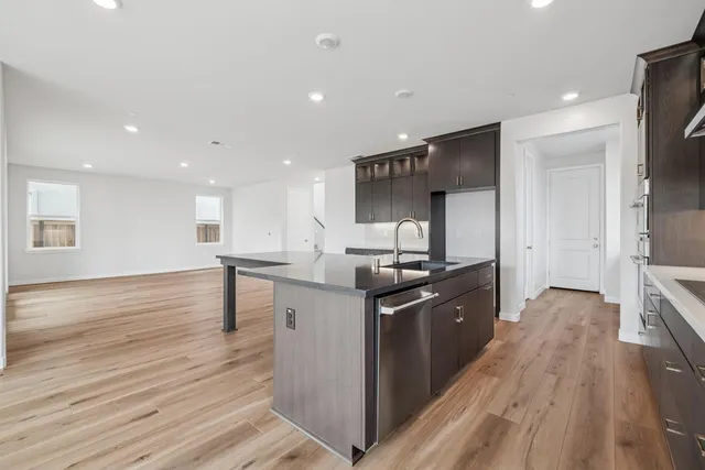 a kitchen with stainless steel appliances granite countertop a sink stove and wooden floor