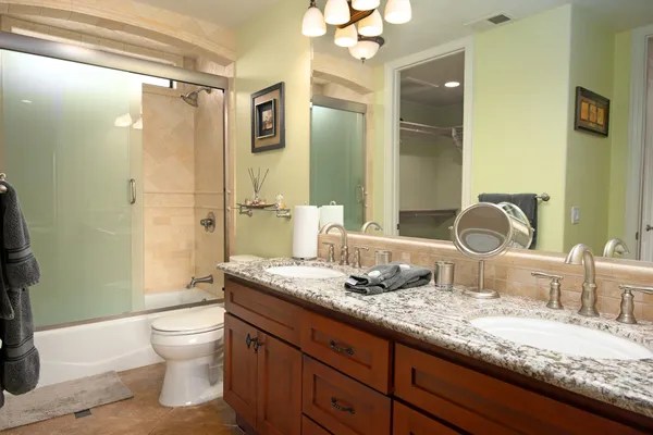 a bathroom with a granite countertop sink toilet and shower