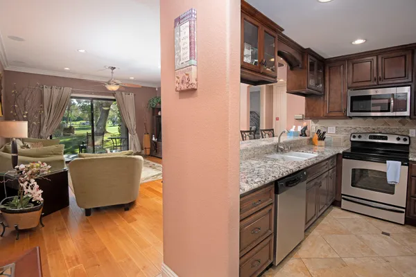 a kitchen with stainless steel appliances granite countertop a stove a sink and a microwave