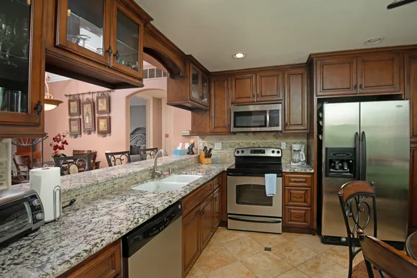a kitchen with granite countertop a stove cabinets and stainless steel appliances