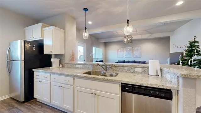 a kitchen with a sink dishwasher a refrigerator and cabinets