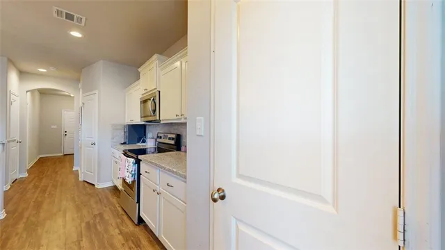 a kitchen with stainless steel appliances granite countertop white cabinets sink and stove