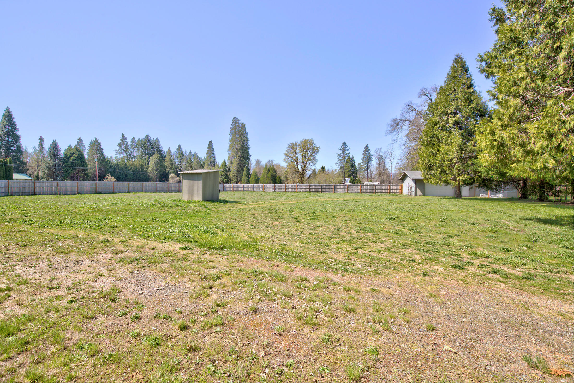 4550 Holland Loop Road Cave Junction, OR 97523 - Photo 28 of 39 a view of a green field with trees in the background