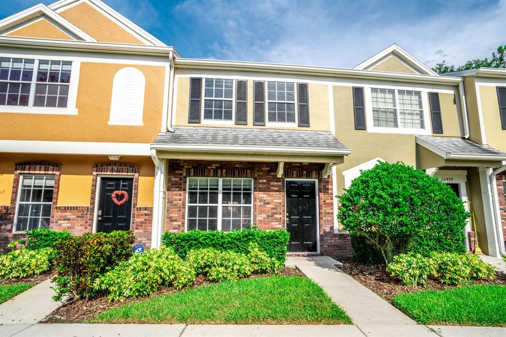 front view of a brick house with a small yard
