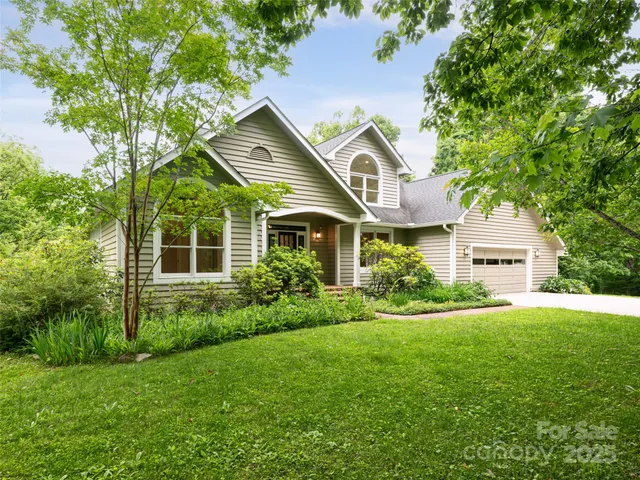 a front view of a house with a yard and trees