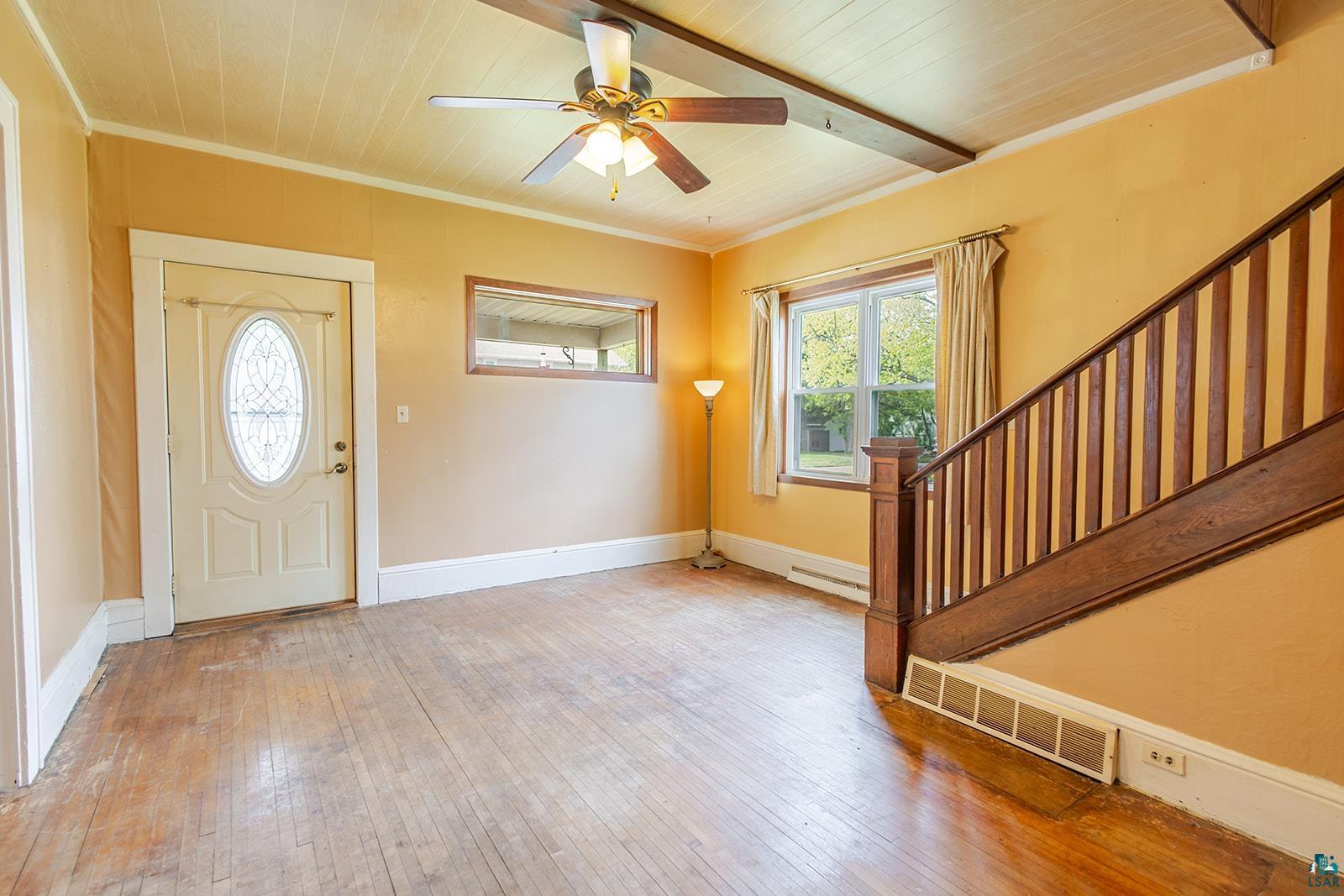 438 9th Street Cloquet, MN 55720 - Photo 9 of 27 Living area featuring wood-finish flooring, a white paneled ceiling, and a ceiling fan with integrated lighting
