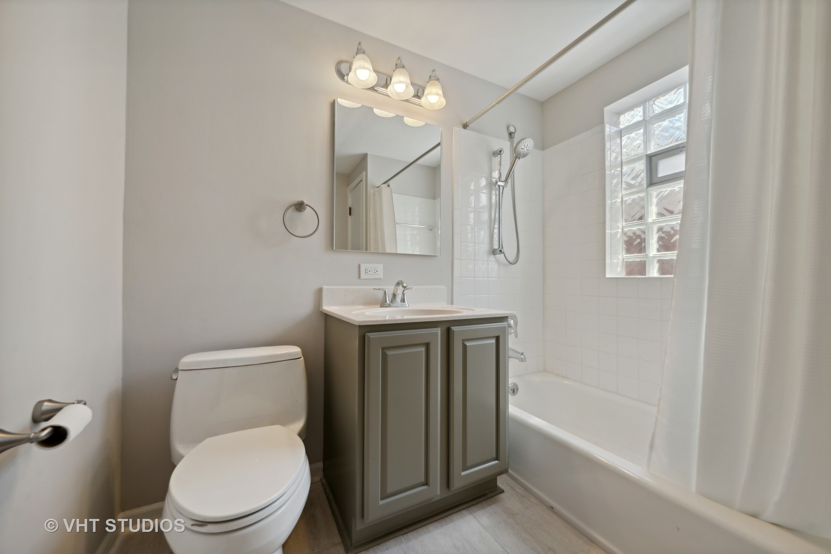 7424 West Gregory Street Chicago, IL 60656 - Photo 13 of 17 a bathroom with a toilet a sink a mirror a bathtub and shower