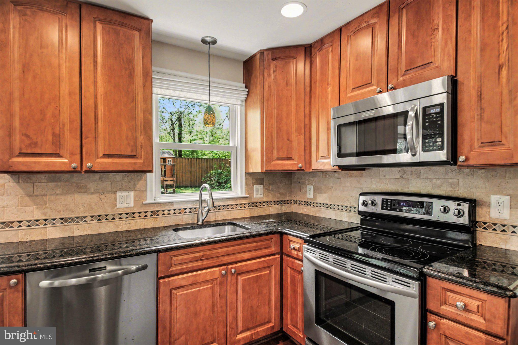 8309 Timber Brook Lane Springfield, VA 22153 - Photo 12 of 39 a kitchen with granite countertop a stove top oven cabinetry a sink and dishwasher
