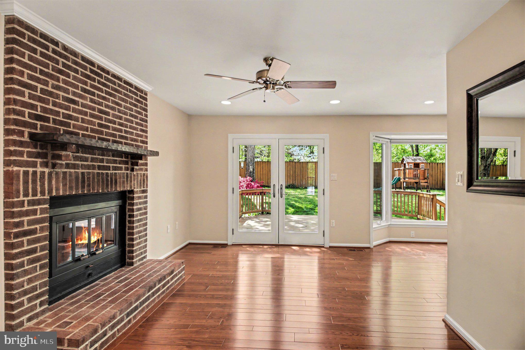 8309 Timber Brook Lane Springfield, VA 22153 - Photo 16 of 39 a view of an empty room with wooden floor fireplace and a window