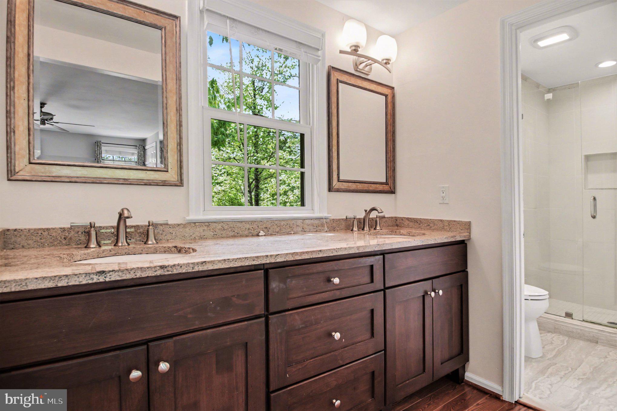 8309 Timber Brook Lane Springfield, VA 22153 - Photo 20 of 39 a bathroom with a granite countertop sink a large mirror a and toilet