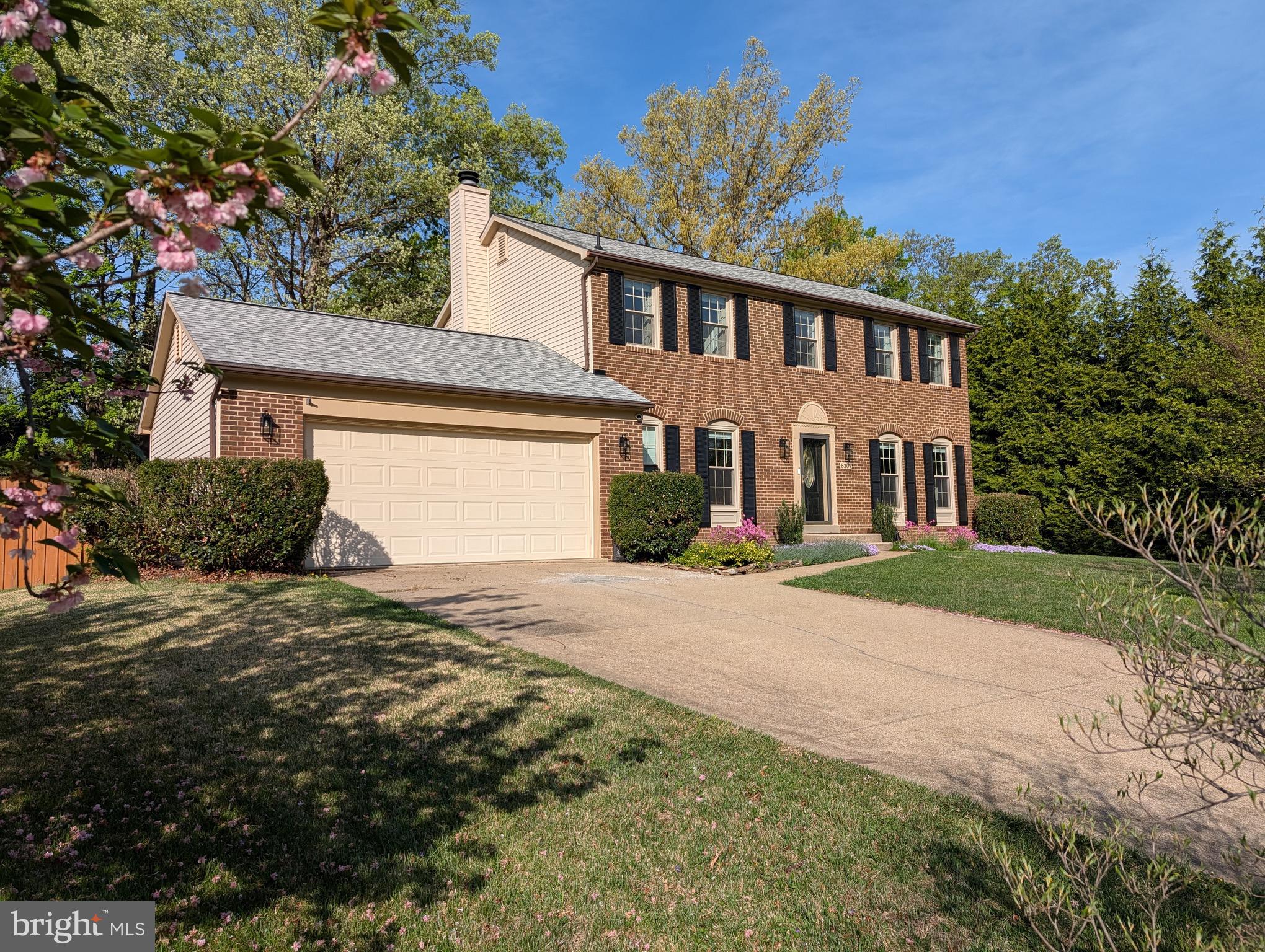 8309 Timber Brook Lane Springfield, VA 22153 - Photo 2 of 39 a front view of a house with a yard and garage