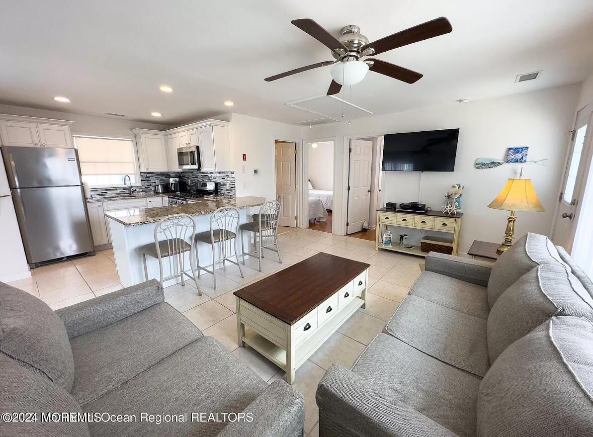 1707 R Baltimore Avenue Lavallette, NJ 08735 - Photo 3 of 11 a living room with furniture a flat screen tv and kitchen view
