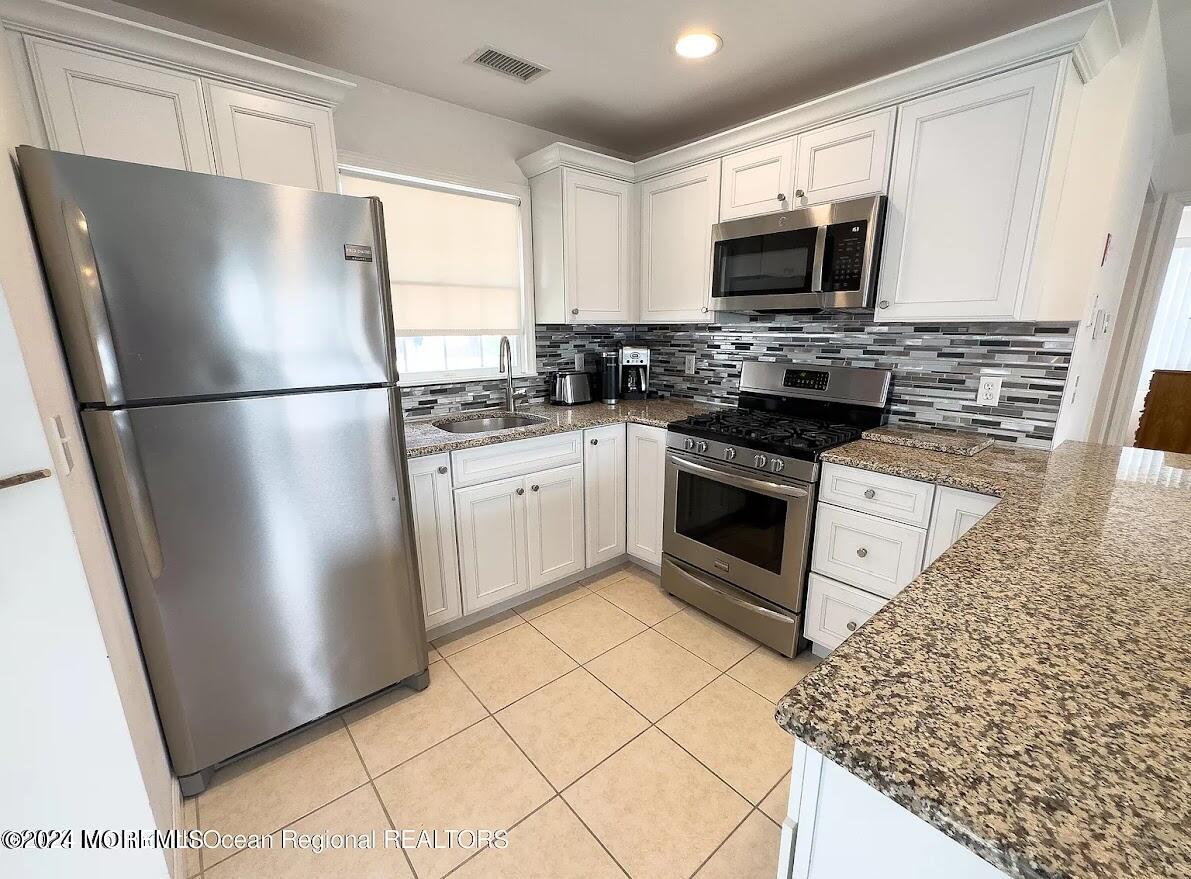 1707 R Baltimore Avenue Lavallette, NJ 08735 - Photo 4 of 11 a kitchen with stainless steel appliances a refrigerator stove microwave and sink
