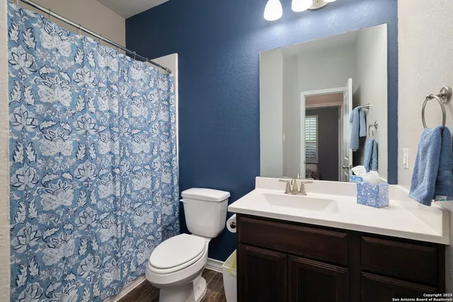 a bathroom with a toilet a sink and mirror