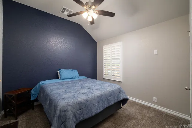 a bedroom with a bed and a chandelier fan