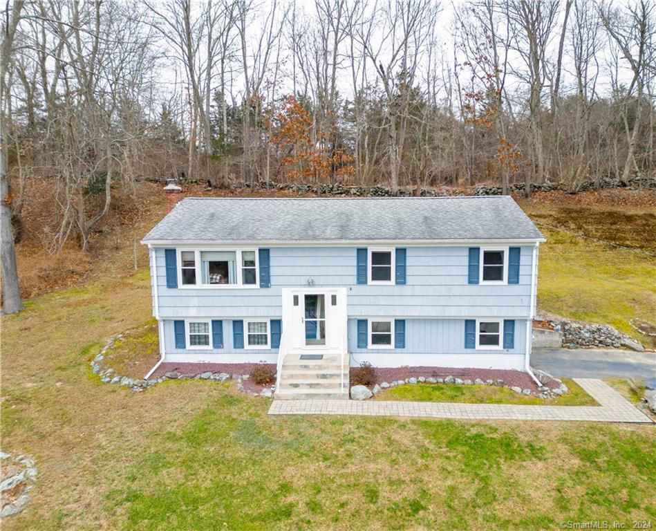 a aerial view of a house next to a big yard with large trees