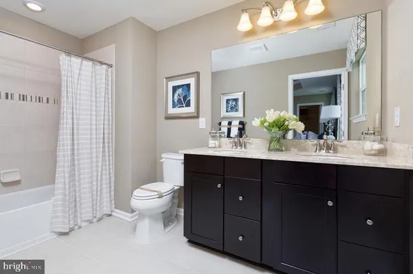 a bathroom with a double vanity sink toilet and a mirror