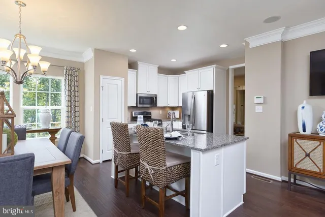 a dining room with furniture a chandelier and wooden floor