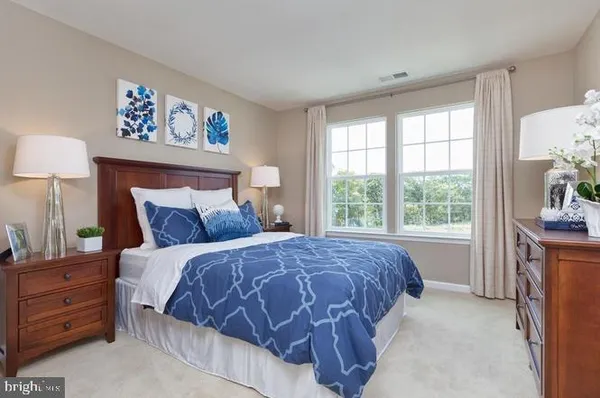 a bed sitting in a bedroom next to a window